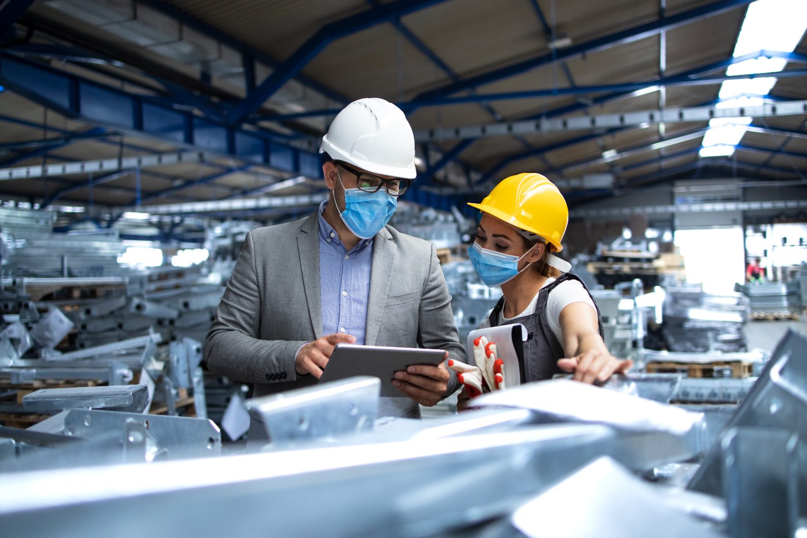 Factory manager and engineer reviewing production data on a tablet