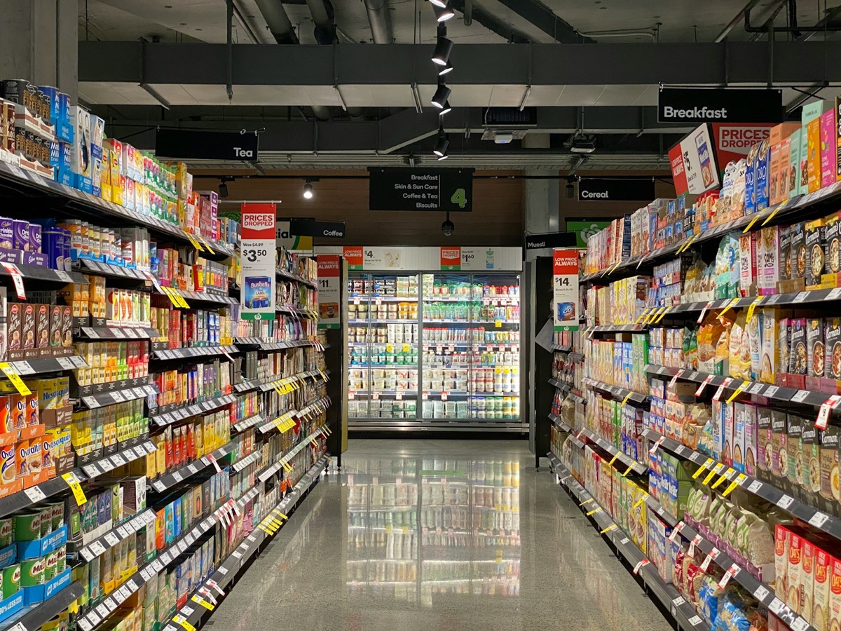 Supermarket aisle with shelves of packaged consumer goods on both sides